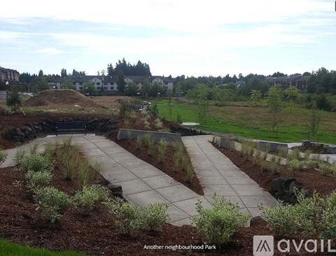 A park with a stone pathway and a grassy area.