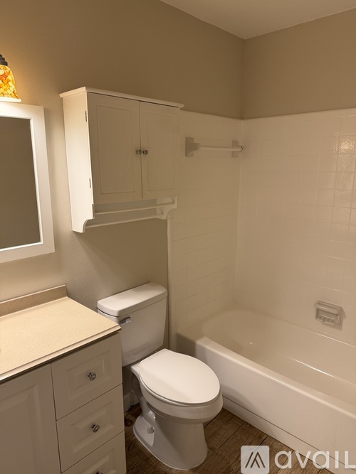 A white toilet sits next to a bathtub in a bathroom.