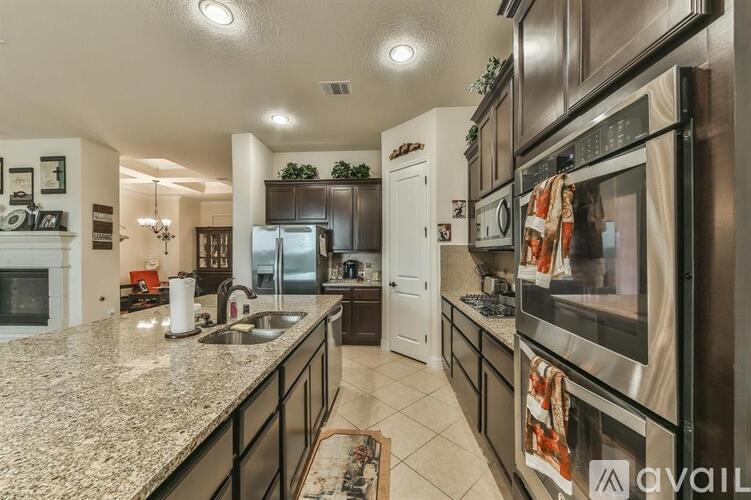 A modern kitchen with granite countertops and stainless steel appliances.