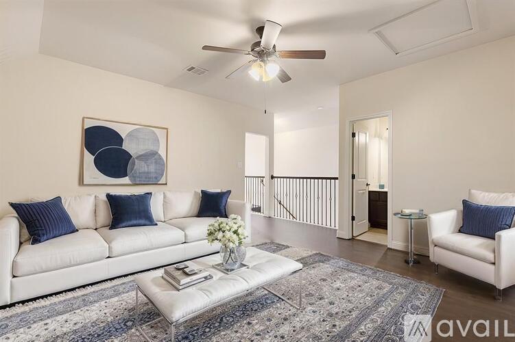 A living room with a white couch, a coffee table, and a painting on the wall.