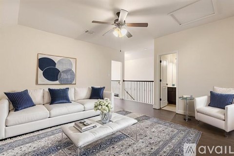 A living room with a white couch, a coffee table, and a painting on the wall.