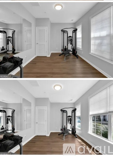 A spacious room with a gym setup and a large mirror.