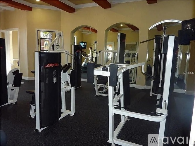 A gym with a variety of equipment including a weight machine and a squat rack.