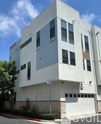 A modern building with a white facade and a garage door.