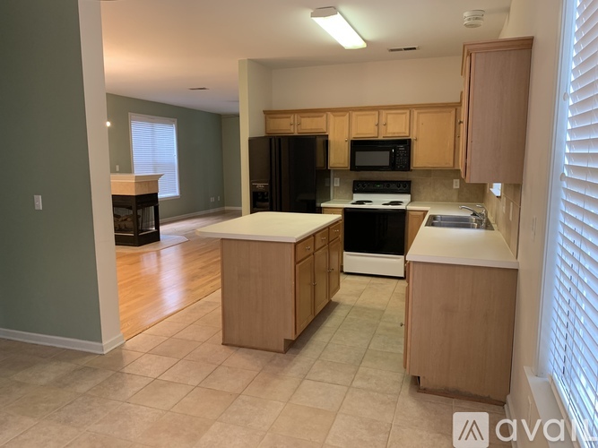 A kitchen with wooden cabinets and black appliances.