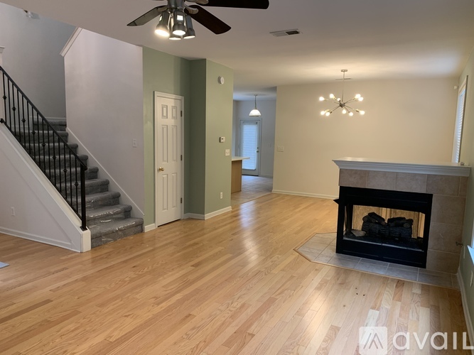 A living room with a fireplace and a staircase.