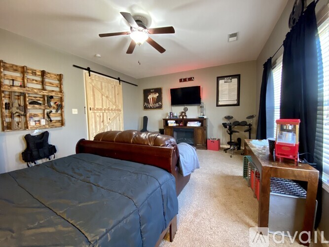 A bedroom with a bed, a ceiling fan, and a chair.