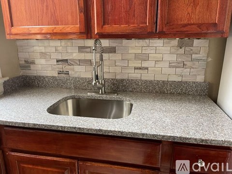 A kitchen counter with a sink and a faucet.