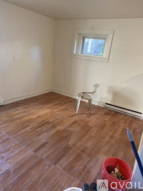 A room with wooden flooring and a white chair.