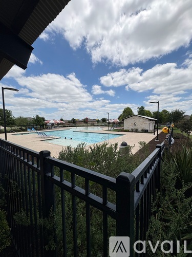 A pool surrounded by a black fence with the logo "avai" on it.