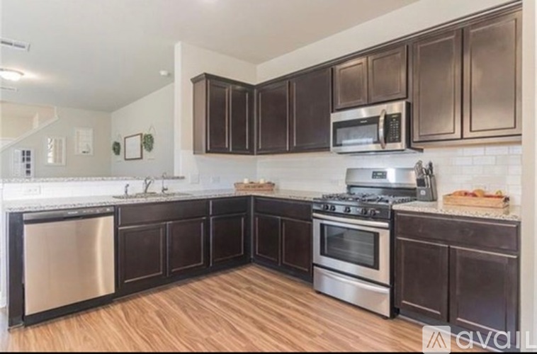 A kitchen with dark brown cabinets and stainless steel appliances.
