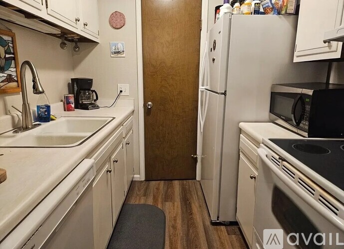 A kitchen with a sink, refrigerator, and stove.