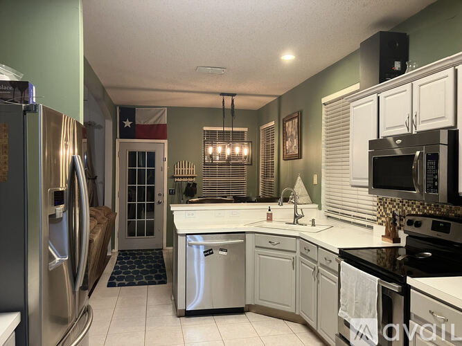 A kitchen with a refrigerator on the left and a microwave on the right.