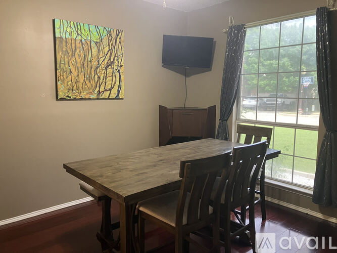 A dining room with a wooden table and chairs.