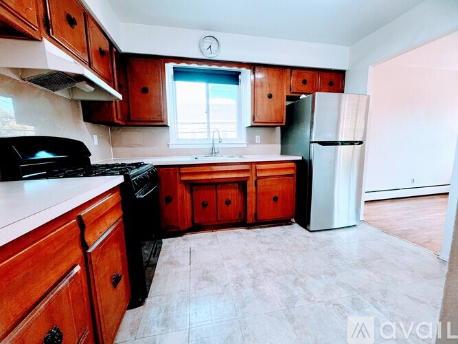 A kitchen with wooden cabinets and a black stove top oven.