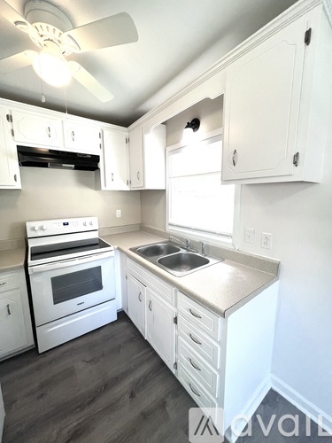 A kitchen with white cabinets and a stove top oven.