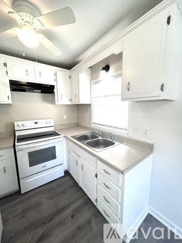 A kitchen with white cabinets and a stove top oven.