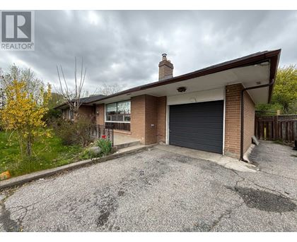A house with a grey garage door and a brown roof.