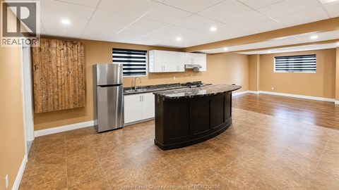 A kitchen with a refrigerator, cabinets, and a countertop.