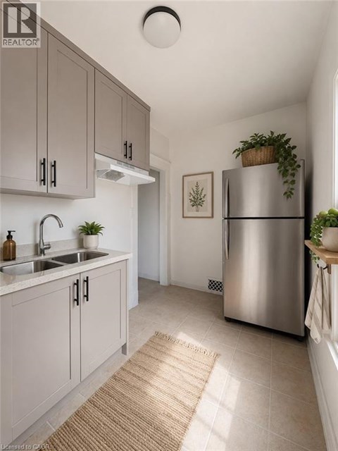 A modern kitchen with a stainless steel refrigerator and grey cabinets.