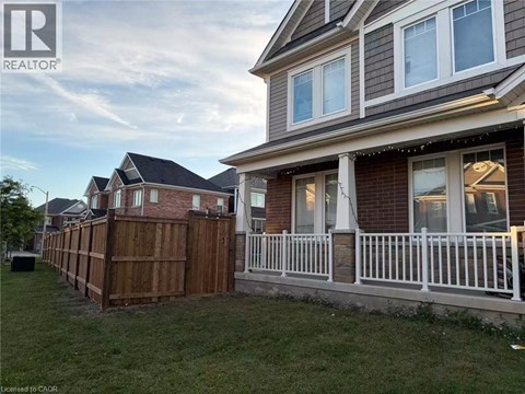 A house with a white fence and a brown wooden fence in front.