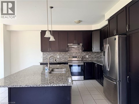 A modern kitchen with dark brown cabinets and stainless steel appliances.