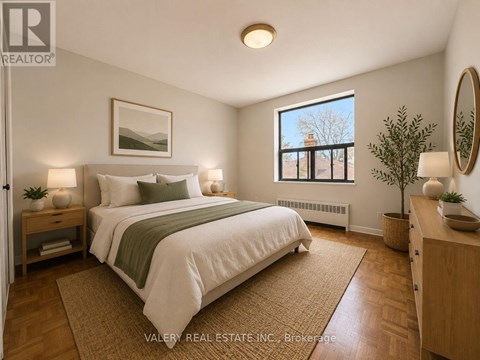 A bedroom with a large bed and a window overlooking a balcony.