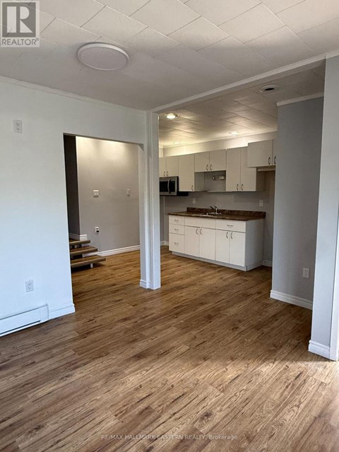 A realtor photo of a kitchen and living room with wood floors.