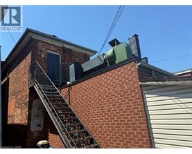 A red brick building with a metal staircase leading to a door.