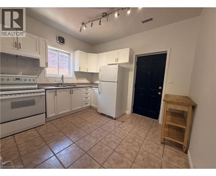 A kitchen with white cabinets and a black door.