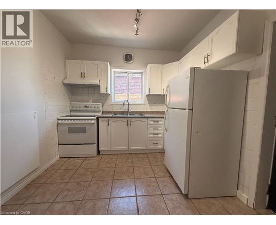 A kitchen with white cabinets and appliances.