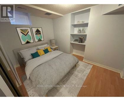 A bedroom with a bed, pillows, and a nightstand.
