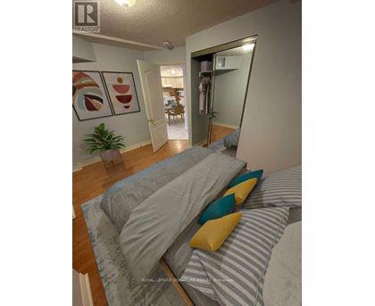 A bedroom with a bed and a plant.