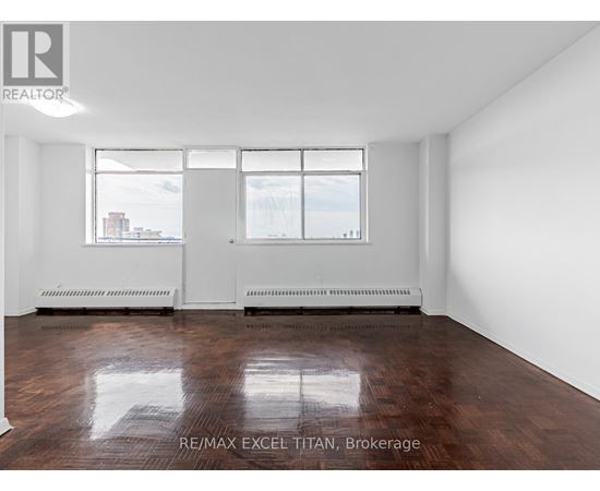 Empty room with white walls and wood flooring.