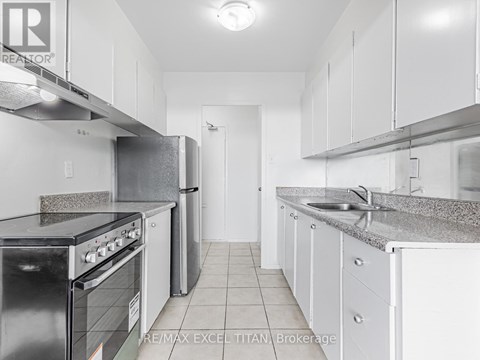 A kitchen with white cabinets and a black stove top oven.