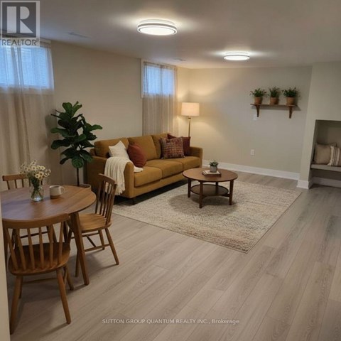 A living room with a brown couch, a wooden coffee table, and a dining table with chairs.