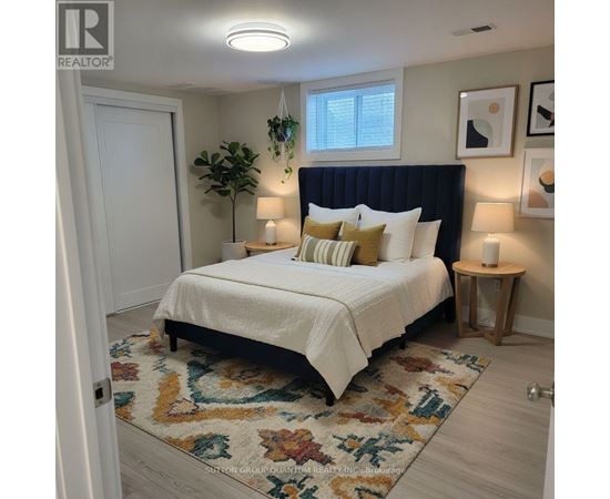 A bedroom with a white bed and a black headboard.