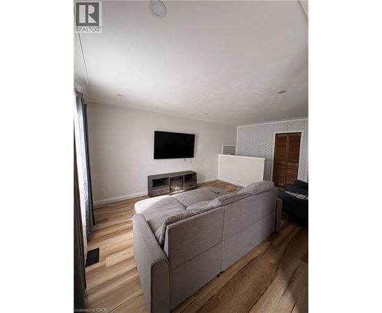 A room with wooden floors and a white ceiling with a light fixture.