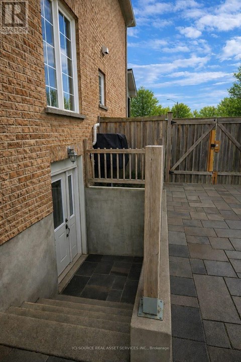 A small patio with a white door and a brick wall.