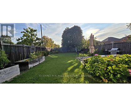 A backyard with a wooden fence and a green lawn.