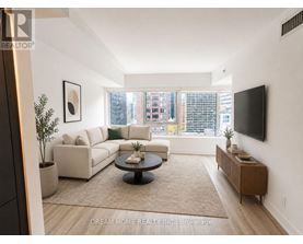 A living room with a couch, coffee table, and a flat screen TV mounted on the wall.