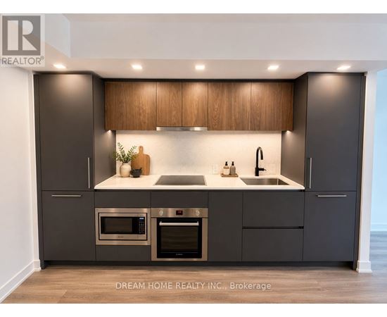 A modern kitchen with dark brown cabinets and stainless steel appliances.