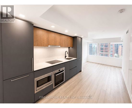 A modern kitchen with dark grey cabinets and wooden accents.
