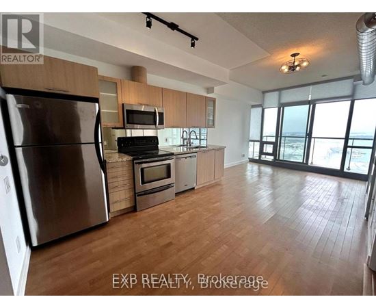 A kitchen with wooden floors and stainless steel appliances.