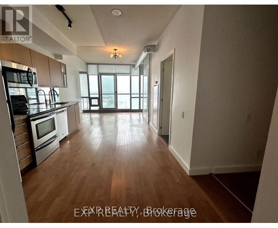 A kitchen with wooden floors and stainless steel appliances.