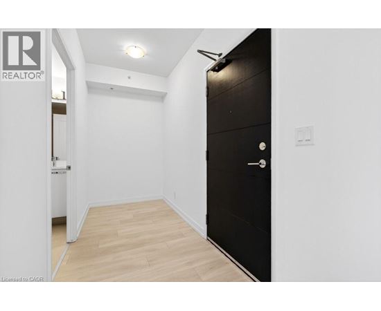 A black door is on the right side of a white wall.