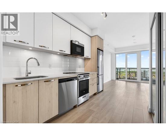 A modern kitchen with wooden cabinets and stainless steel appliances.