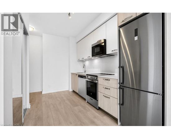 A modern kitchen with stainless steel appliances and wooden cabinets.
