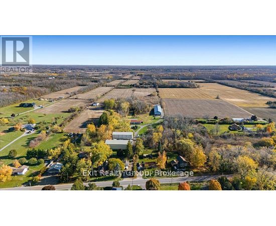 A real estate company logo is superimposed on a picture of a rural landscape.