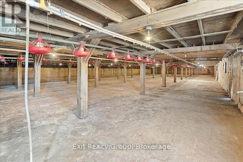 A large, empty warehouse space with wooden beams and concrete floors.